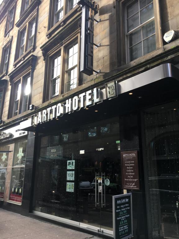 uma loja em frente a um hotel numa rua da cidade em Artto Hotel em Glasgow
