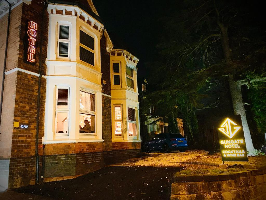 a building with a sign in front of it at night at The Gungate Hotel - Cocktails and Wine Bar in Tamworth