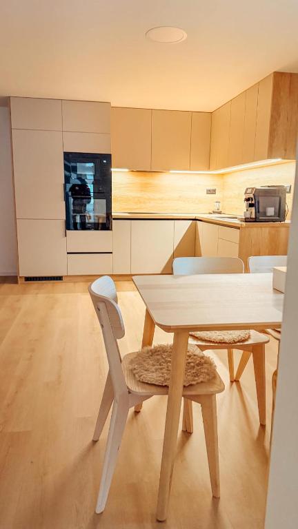 a kitchen with a table and chairs in a room at Apartmány ALMA Šumiac in Šumiac