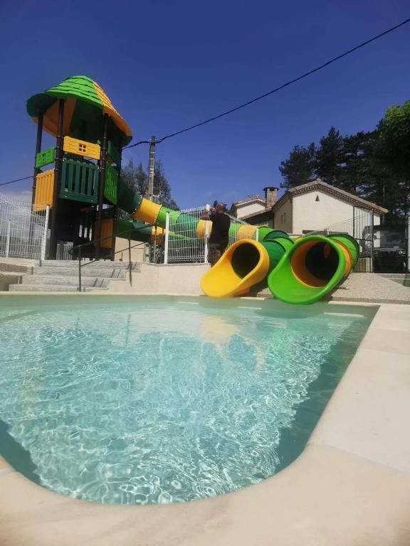 a pool of water next to a playground at ZEcamping 4 étoiles animaux acceptés avec piscine chauffée toboggan et tennis in Ucel