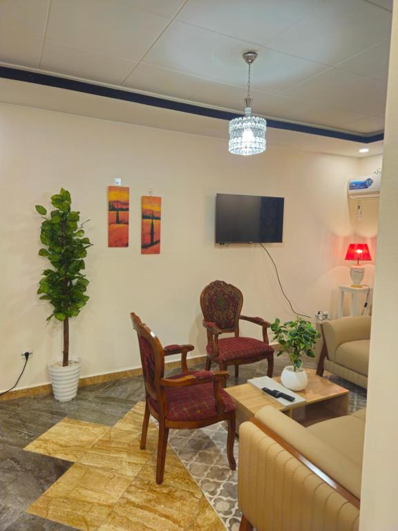 a living room with a couch and chairs and a tv at Joli F3 in Dar el Beïda
