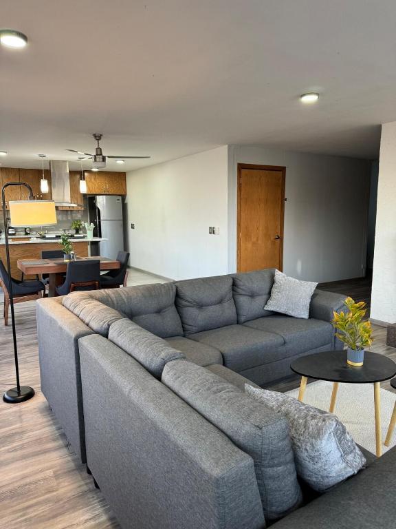 a living room with a gray couch and a table at Deluxe Loft Air Conditioning Downtown Parking in Tepatitlán de Morelos