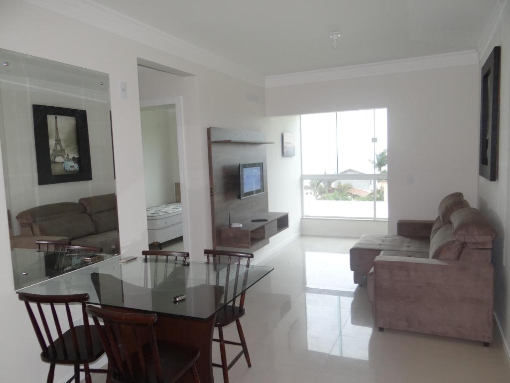 a living room with a glass table and a couch at Residencial Galápagos in Imbituba