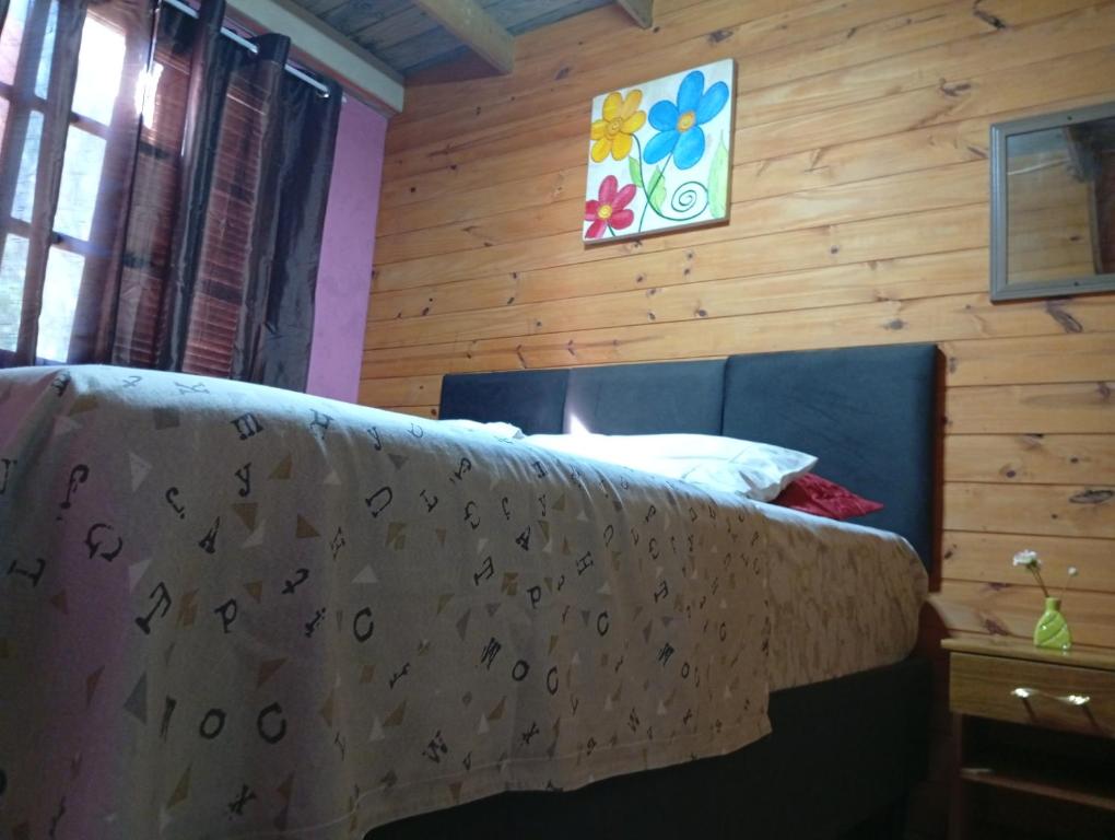 a bedroom with a bed with a wooden wall at De Férias na Fronteira in Xuí