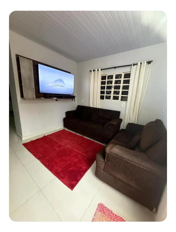 a living room with a couch and a flat screen tv at Casa da Vila de São Jorge in Sao Jorge