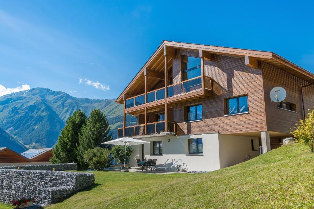 a house on a hill with mountains in the background at Relax - Haus Swiss in Grächen