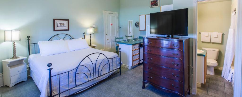 a bedroom with a bed and a flat screen tv at Chipman Hill Suites -Yeats House in Saint John