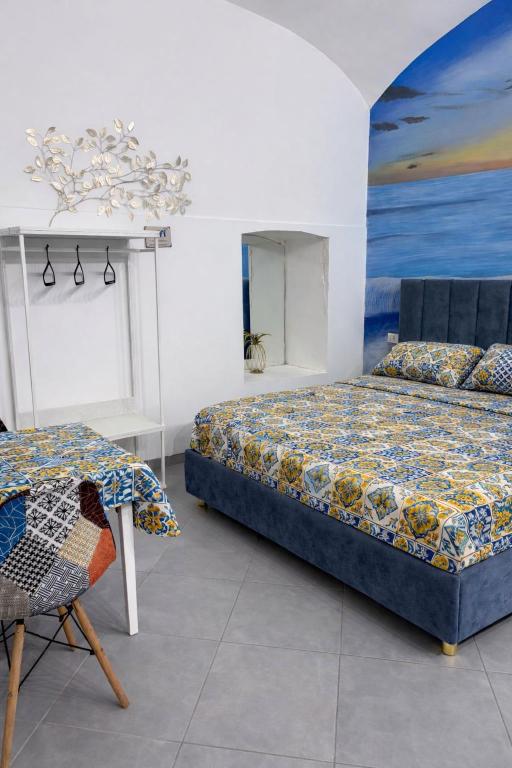 a bedroom with two beds and a table and a painting at Aurora Flavia Suite in Pozzuoli