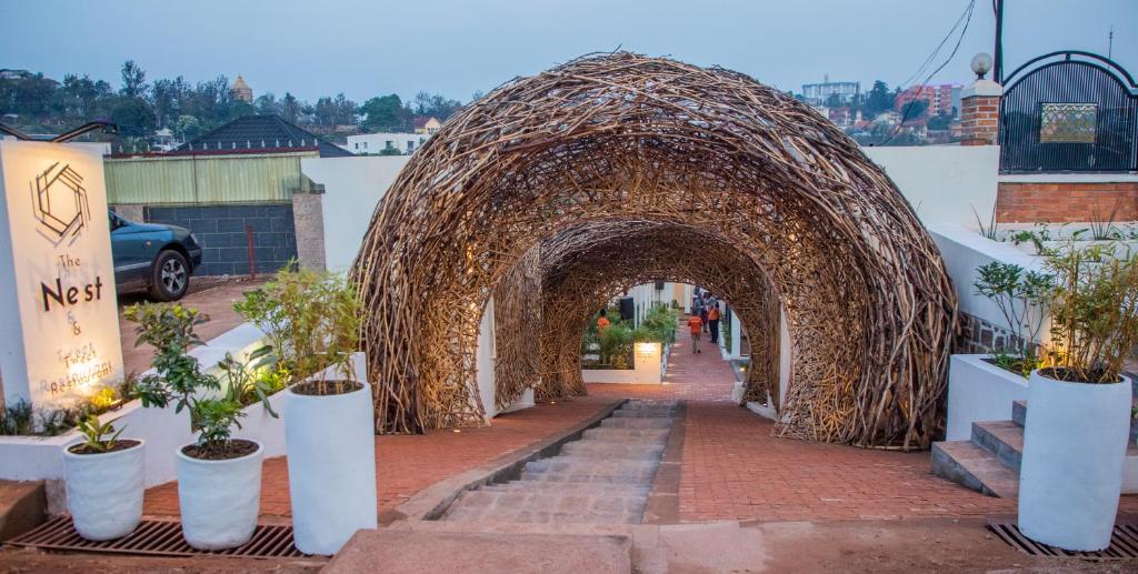 an archway with potted plants on a brick sidewalk at The Nest - Complimentary Massage Included in Kigali