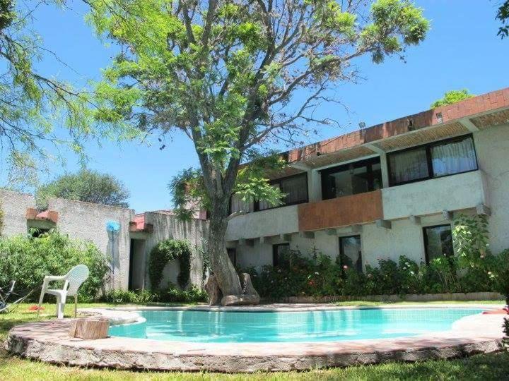 una casa con piscina frente a un árbol en Hotel Casa Pahpaqui, en Tequisquiapan