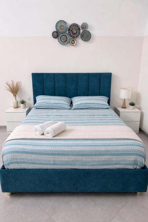 a bedroom with a blue bed with towels on it at Diana Flavia Suites in Pozzuoli