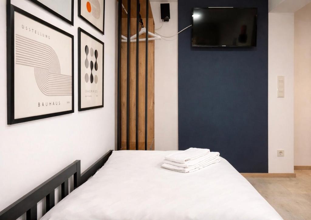 a bedroom with a bed and a tv on a wall at SOLO by Tendo Stay - Comfort Housing in Falkensee
