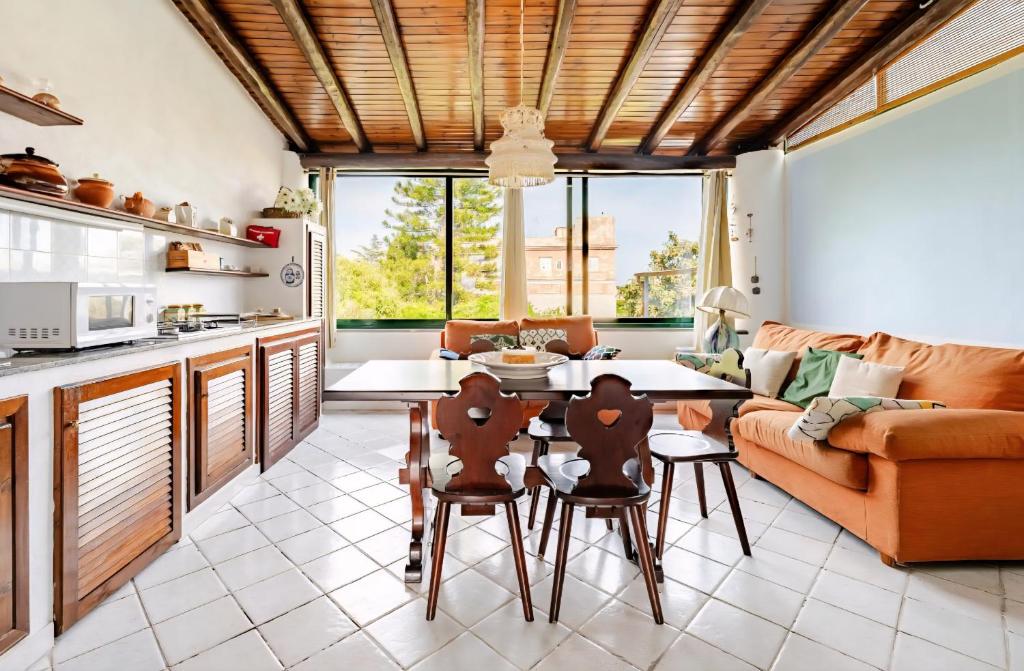 a kitchen and living room with a table and chairs at Casa DAFNE in Lipari