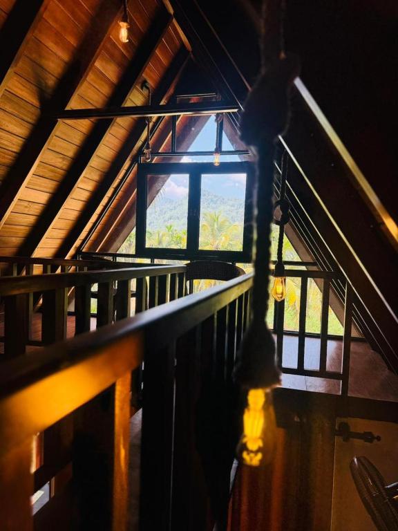a room with a window and a wooden railing at Sinharaja Brook Cabana in Deniyaya