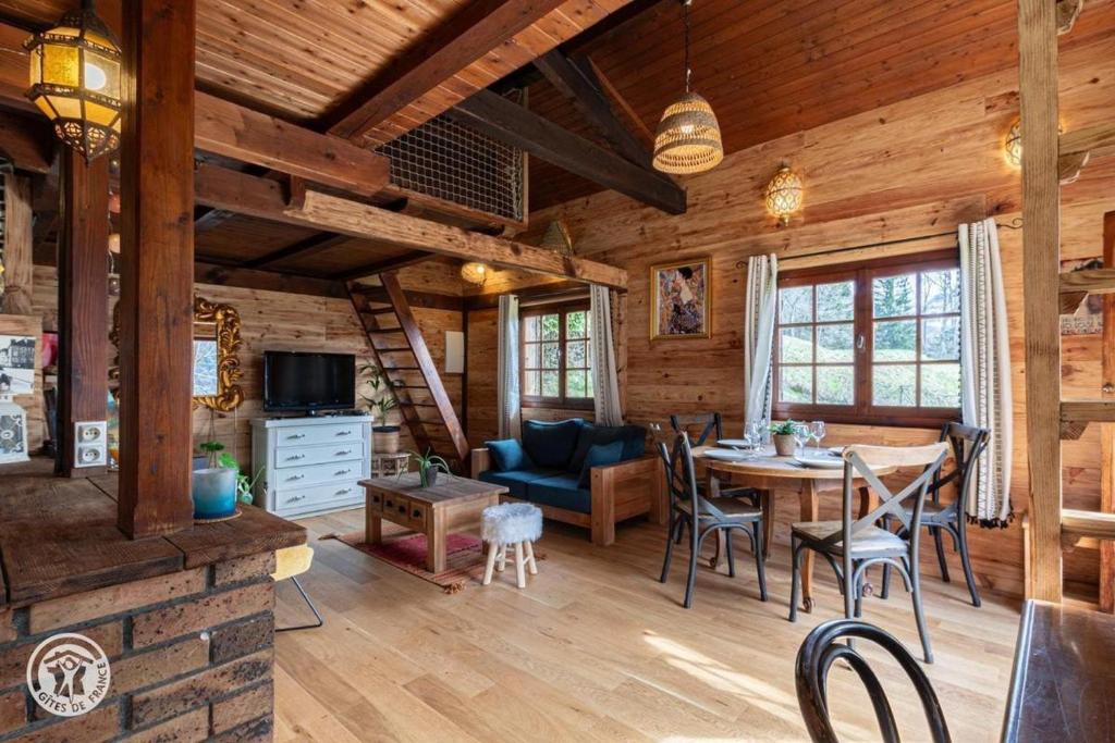 a dining room and living room of a log cabin at Petit chalet l Authentique Annecy in Dingy-Saint-Clair