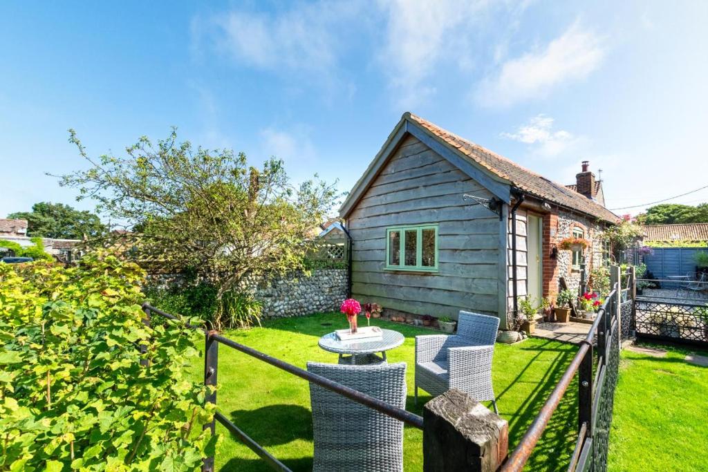 a garden with a table and chairs in front of a house at 1 Bed in Trimingham oc-h29803 in Trimingham