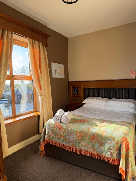 a bedroom with a bed and a window at Crown & Anchor Inn in Brough