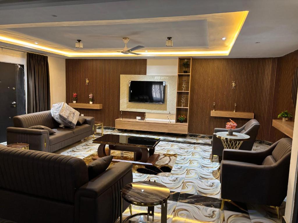 a living room with couches and a flat screen tv at Grand View Lodge in Trofwi