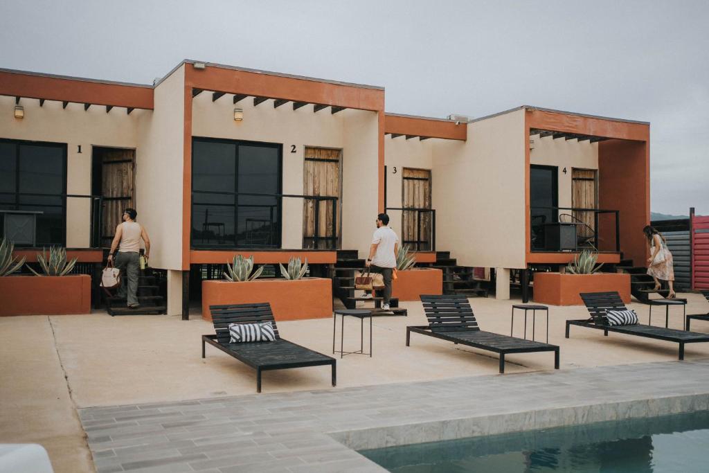 a building with chairs and a pool in front of it at Casas VV in Valle de Guadalupe