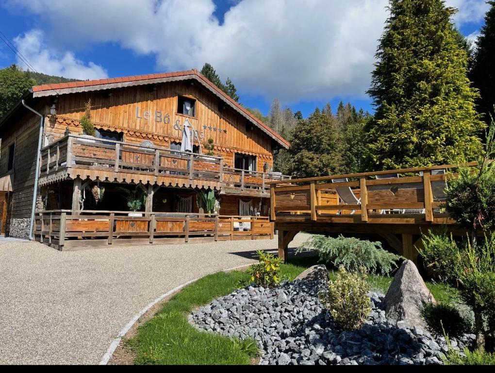a large wooden building with a bridge in front of it at Chalet le Bô & Spa in Bussang