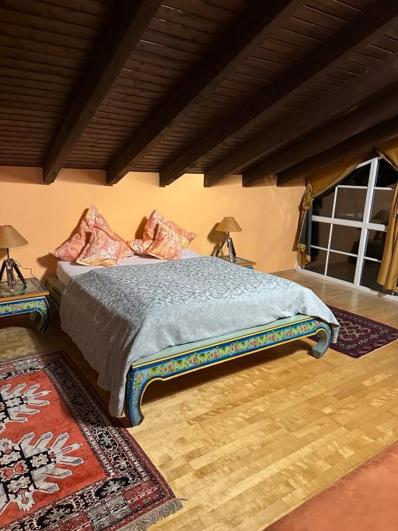 a bed in a room with two lamps and a rug at Gästeresidenz - Hotel - Ruthellen's Home in Planegg