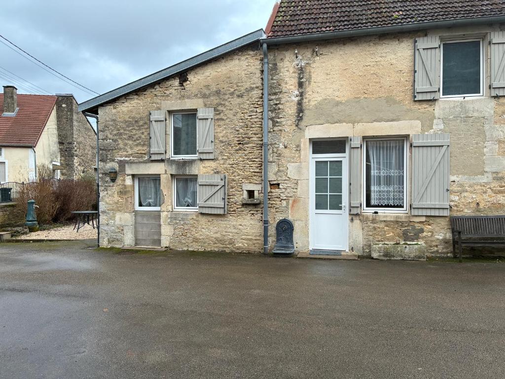 an old brick house with a white door at La petite maison in Rimaucourt