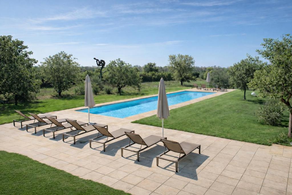 a group of chairs and umbrellas next to a pool at I Mulicchi in Specchia