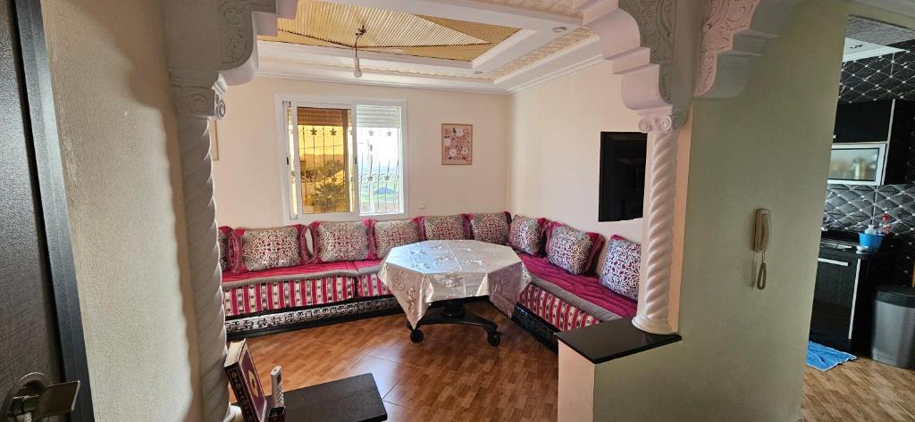 a living room with a red couch and a table at Appartement stylia 2 in Agadir