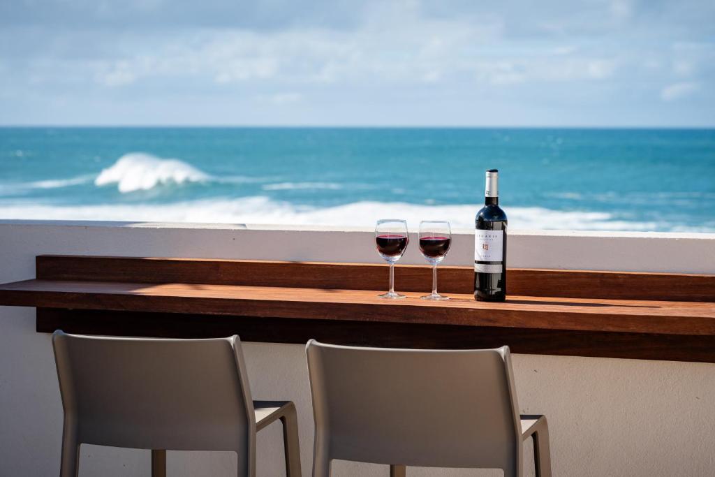 Zwei Gläser Wein stehen auf einem Tisch neben dem Meer in der Unterkunft Salitre in Ajuy