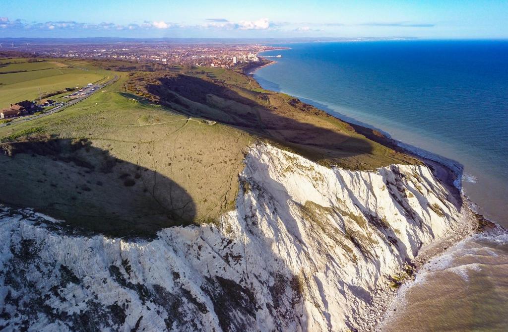 an aerial view of the edge of a cliff near the ocean at StayPoint in Eastbourne