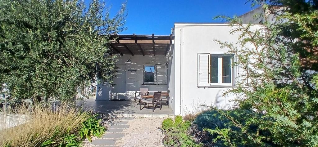 a white house with a table and chairs at Sa Zirighetta in S'archittu Cuglieri