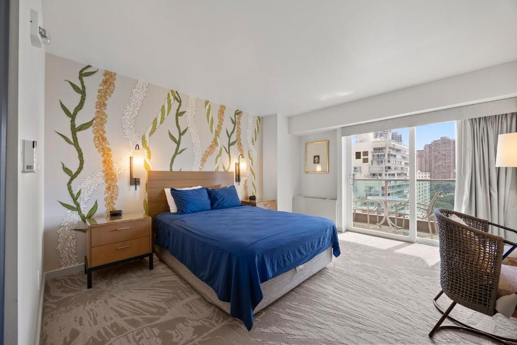 a bedroom with a blue bed and a large window at Ala Moana Hotel _ Ocean view with balcony in Honolulu