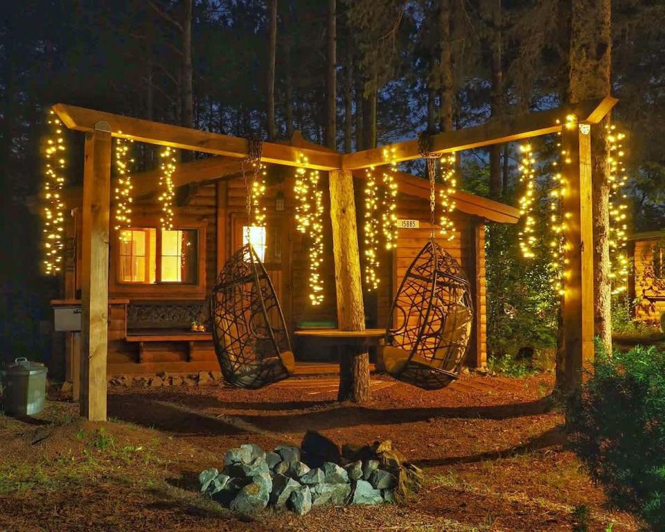 a wooden cabin with christmas lights in the yard at The Timberjack in Hayward