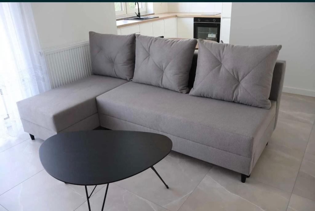 a living room with a couch and a table at Bee happy apartament Kępno in Kępno