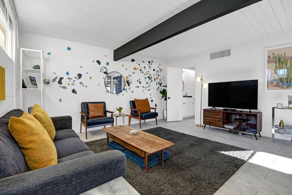 a living room with a couch and a tv at Ocotillo Art Bungalow in Palm Springs