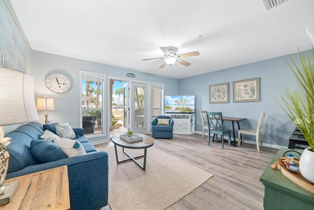 a living room with a blue couch and a table at Grand Caribbean East Poolside Palms in Pensacola