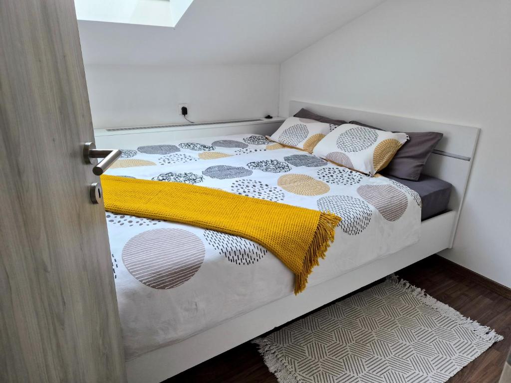 a bedroom with a bed with a yellow blanket on it at Apartment Doroteja in Podplat