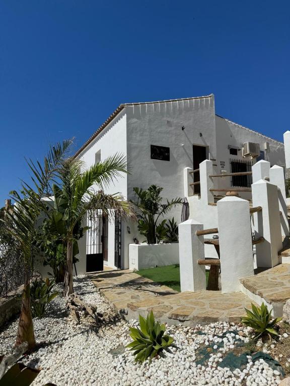 a white house with palm trees in front of it at Villa Lomy Casares in Casares