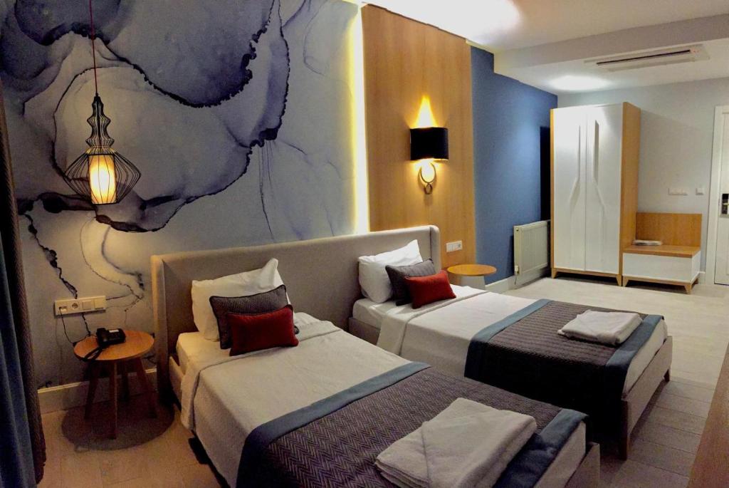 a hotel room with two beds and a couch at Çalcalar Otel in Ula