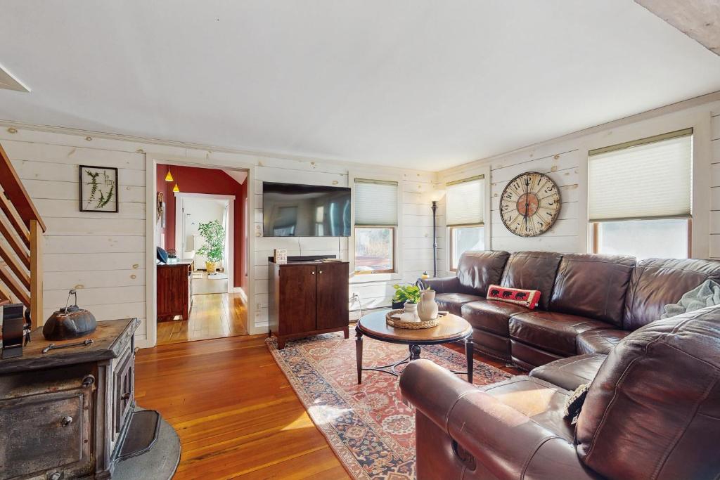 a living room with a leather couch and a table at High Street Retreat in Cavendish