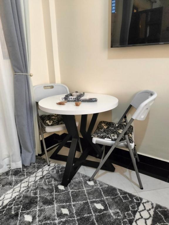 a white table and two chairs in a room at Khalisee homes studio apartment 5 in Voi