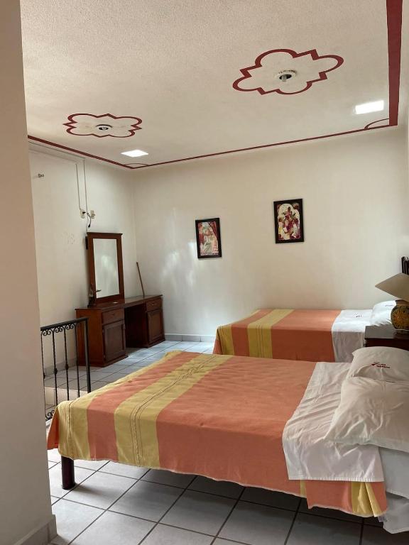 a hotel room with two beds and a mirror at Hotel san ignacio in Oaxaca City
