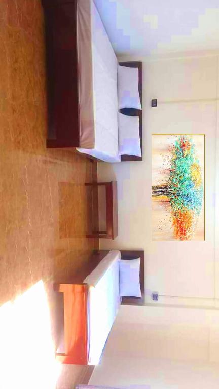 a kitchen with a refrigerator and a painting on the wall at Devagram Guest house in Dergaon