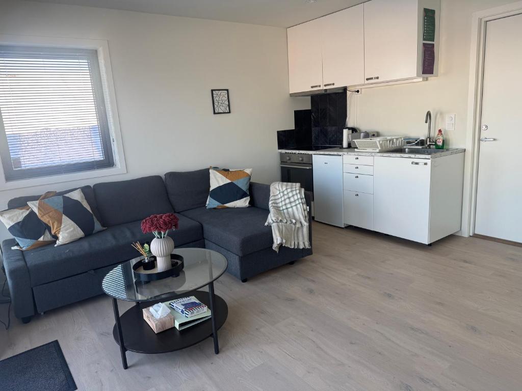 a living room with a blue couch and a kitchen at Modern Flat In Flateby, Enebakk in Flateby