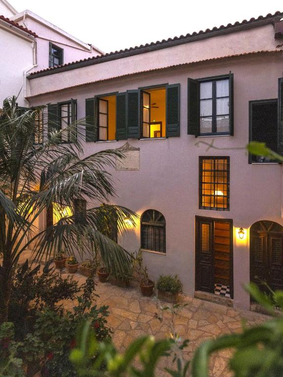 a white house with black windows and a palm tree at Sundial Lodge in Chania