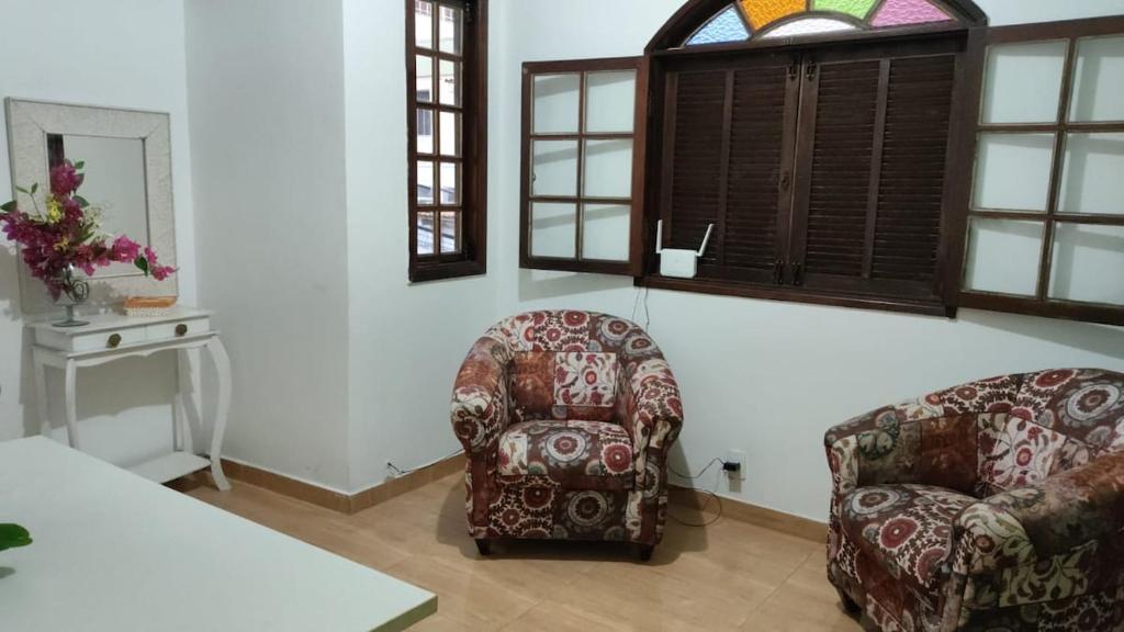 a living room with two chairs and a table at Duque de Caxias Apartmento in Duque de Caxias