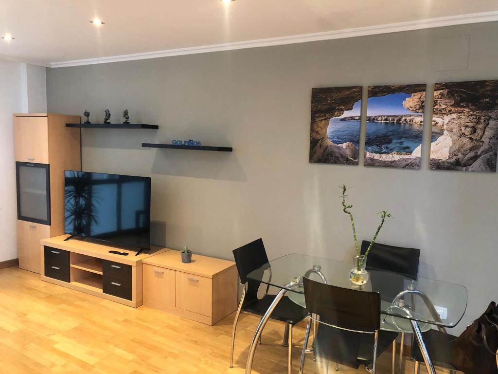 a living room with a glass table and a television at Golfiños in Carballino