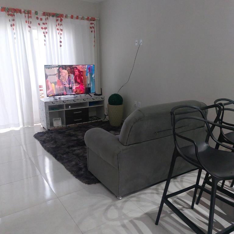 a living room with a couch and a tv at Descanso Paz e sossego com muito aconchego in Prado