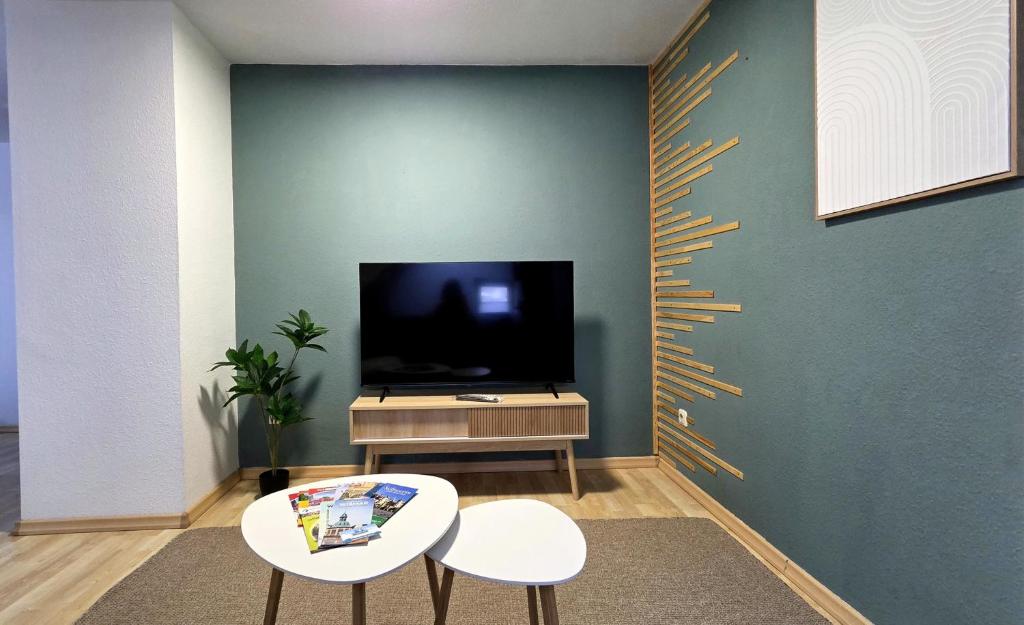 a living room with two tables and a flat screen tv at Apartment am Ostorfer See in Schwerin