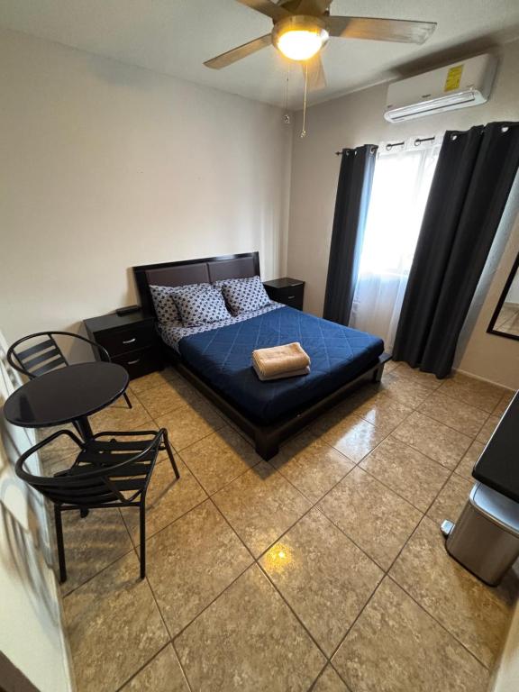 ein Schlafzimmer mit einem blauen Bett, einem Tisch und Stühlen in der Unterkunft Habitacion Arboleda in Saltillo